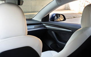 Tesla Model 3 with white interior seating and carbon door panels